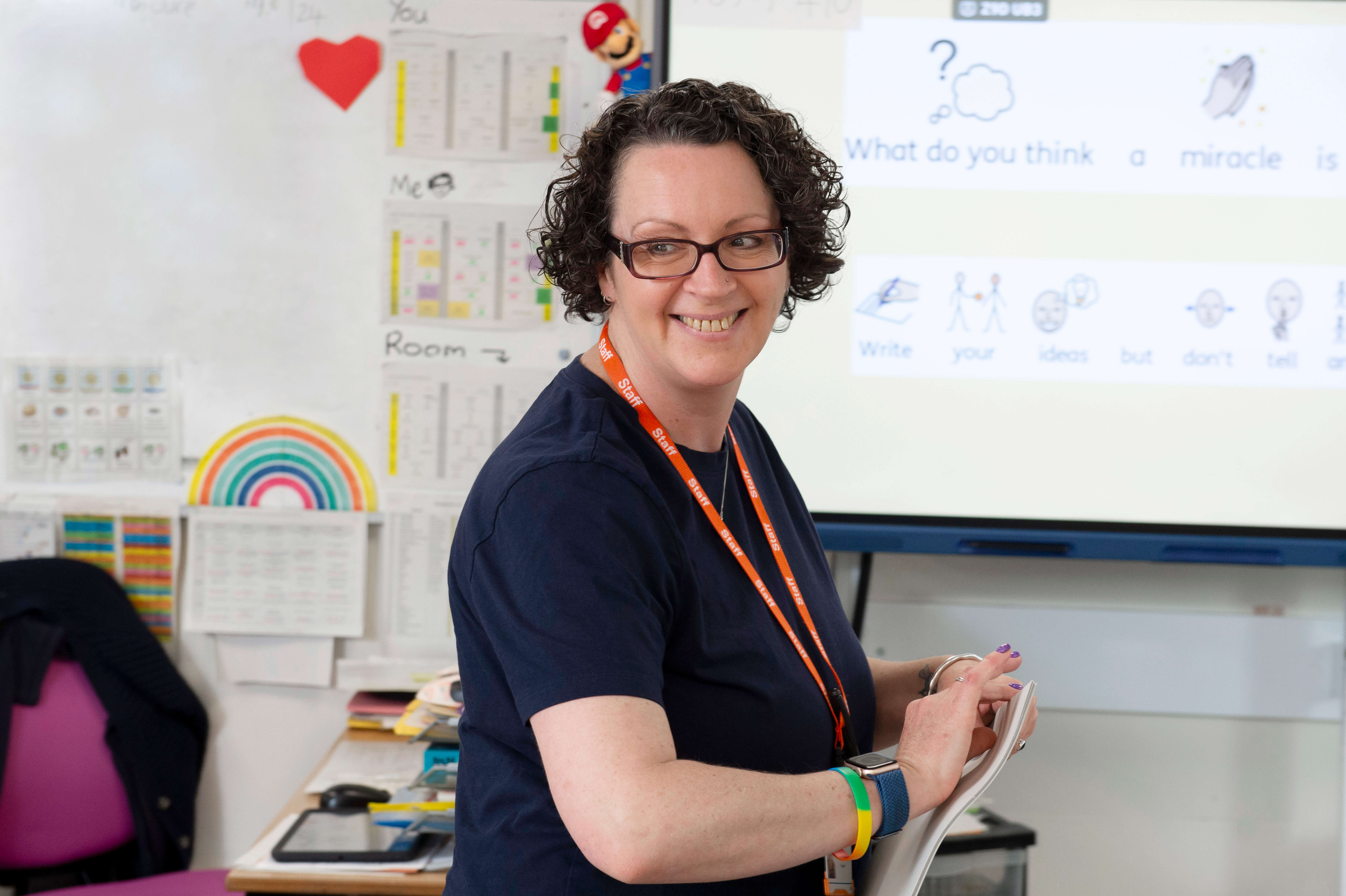Teacher smiling at the front of a classroom