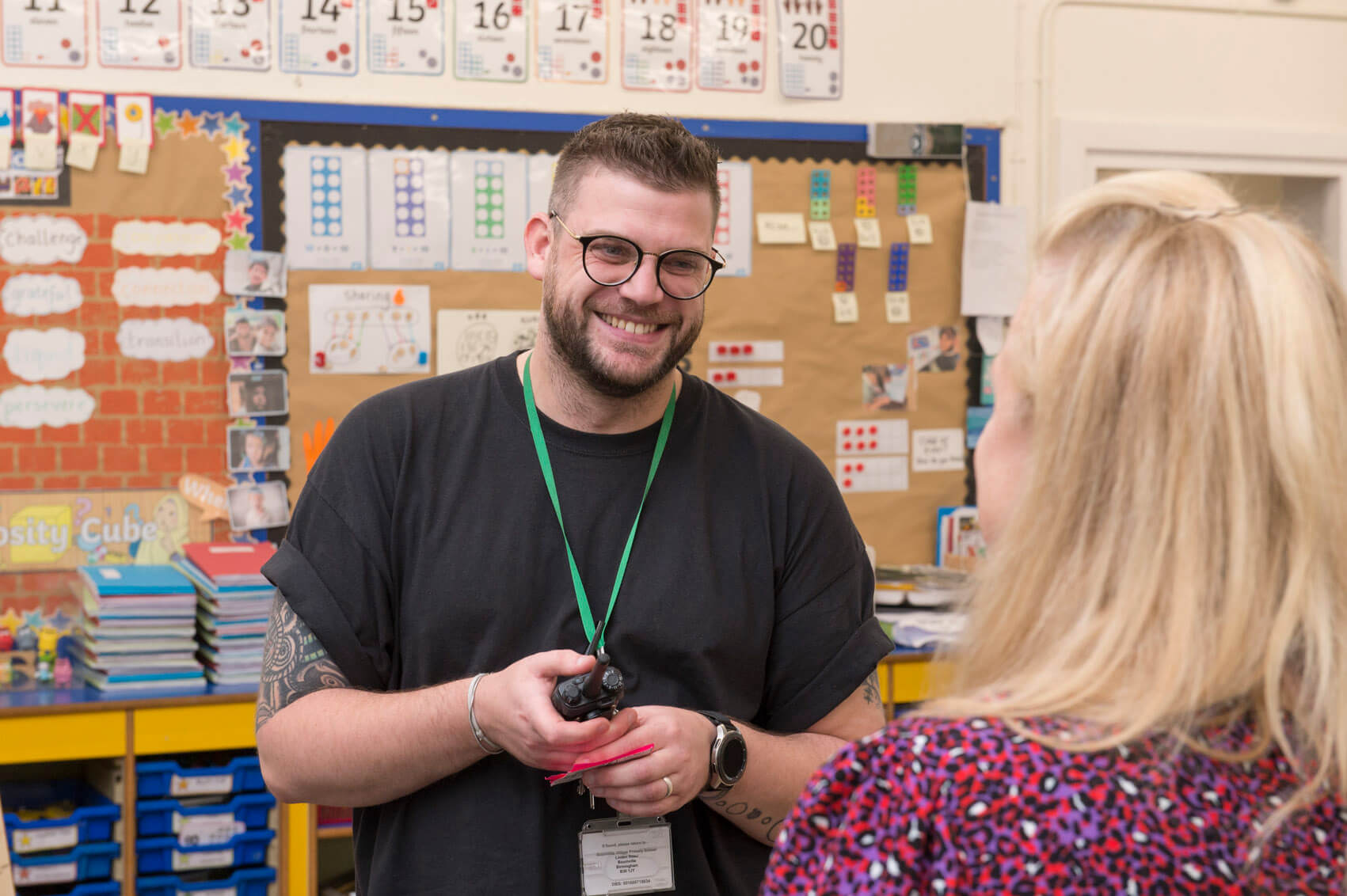 Two primary school teachers laughing in a classroom 