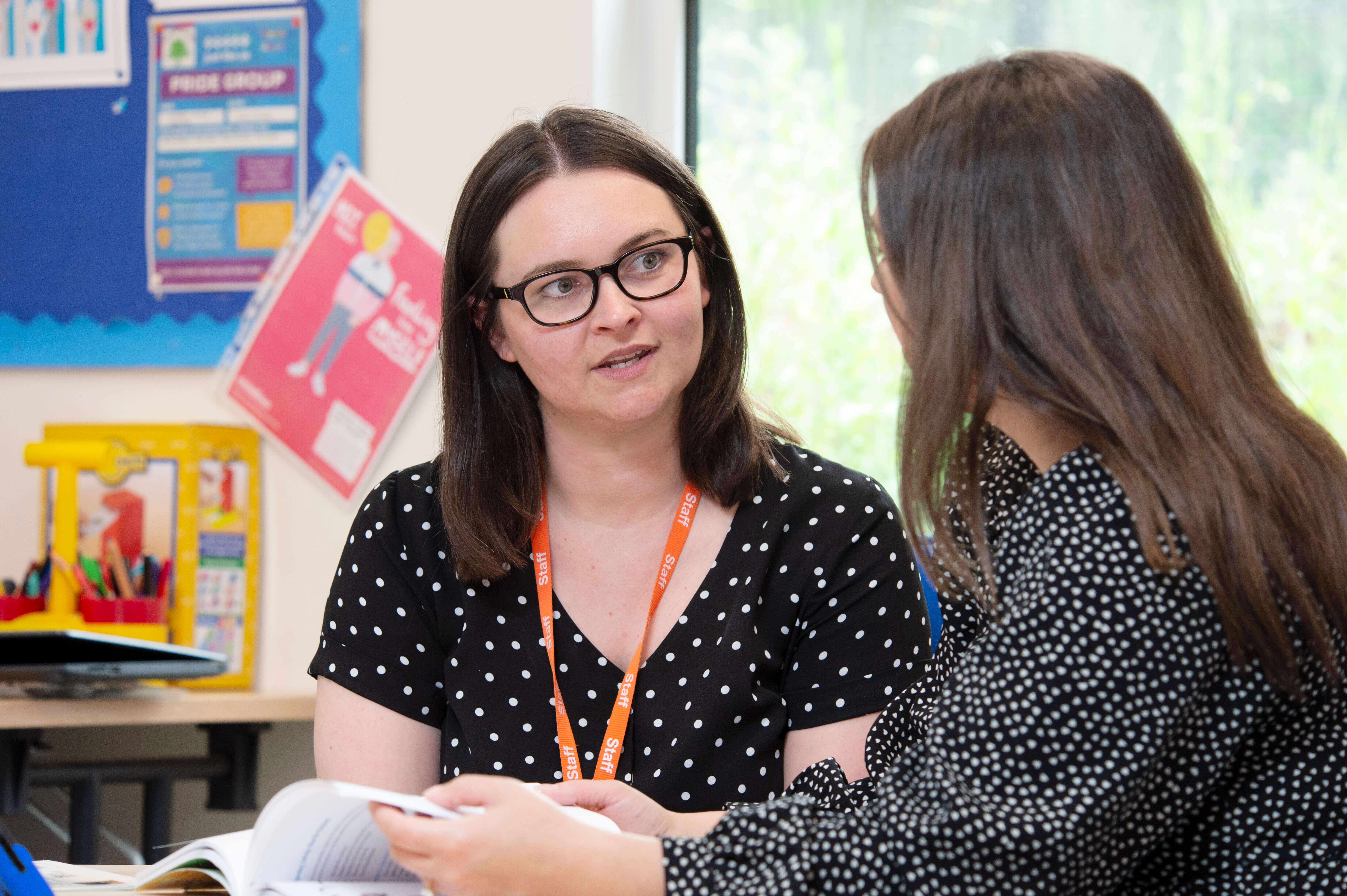 Two teachers talking in a classroom