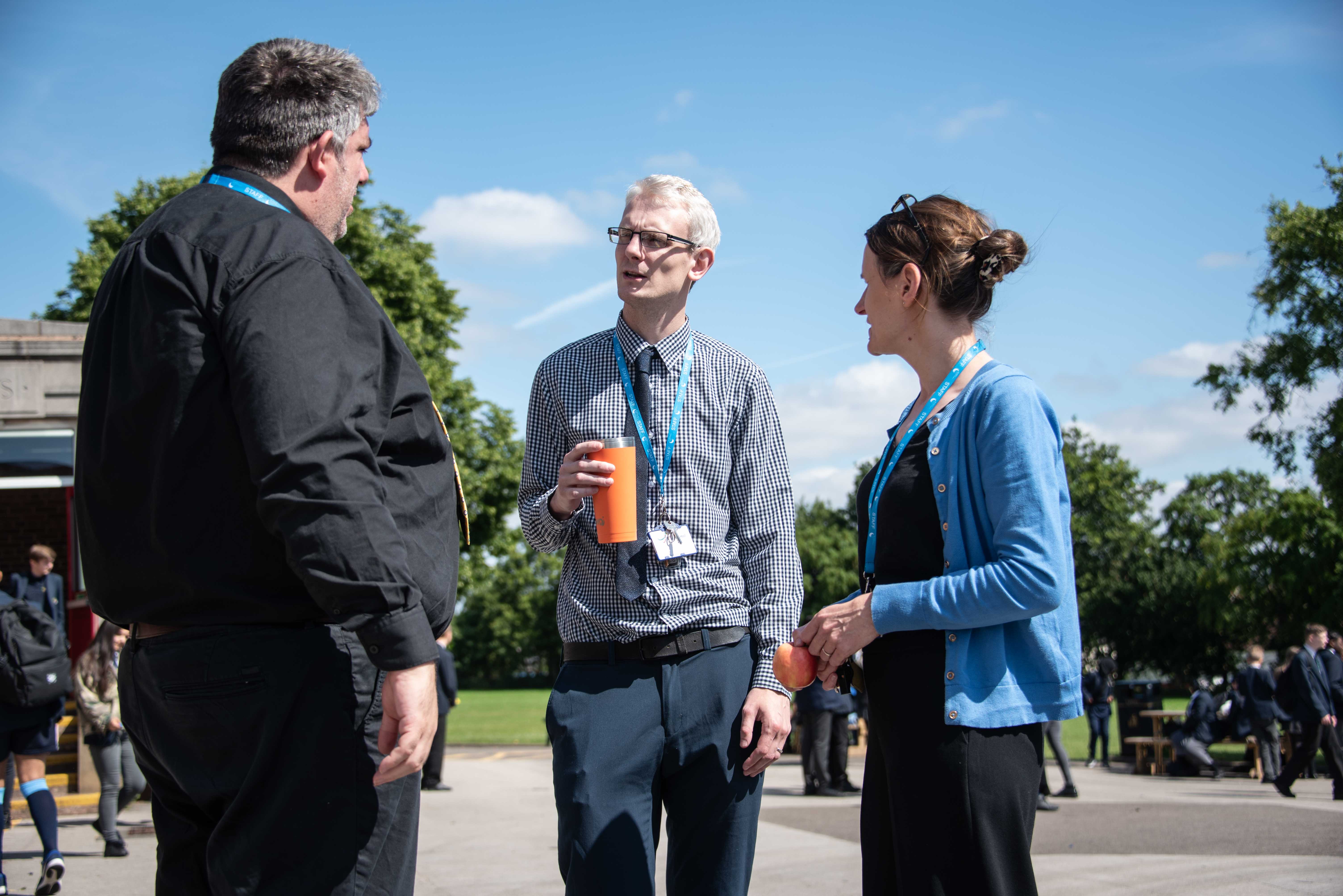 Three teachers talking in the playground