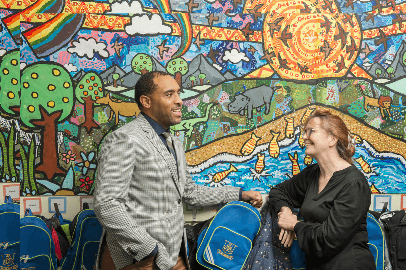 Headteacher and teacher chatting in a school corridor 