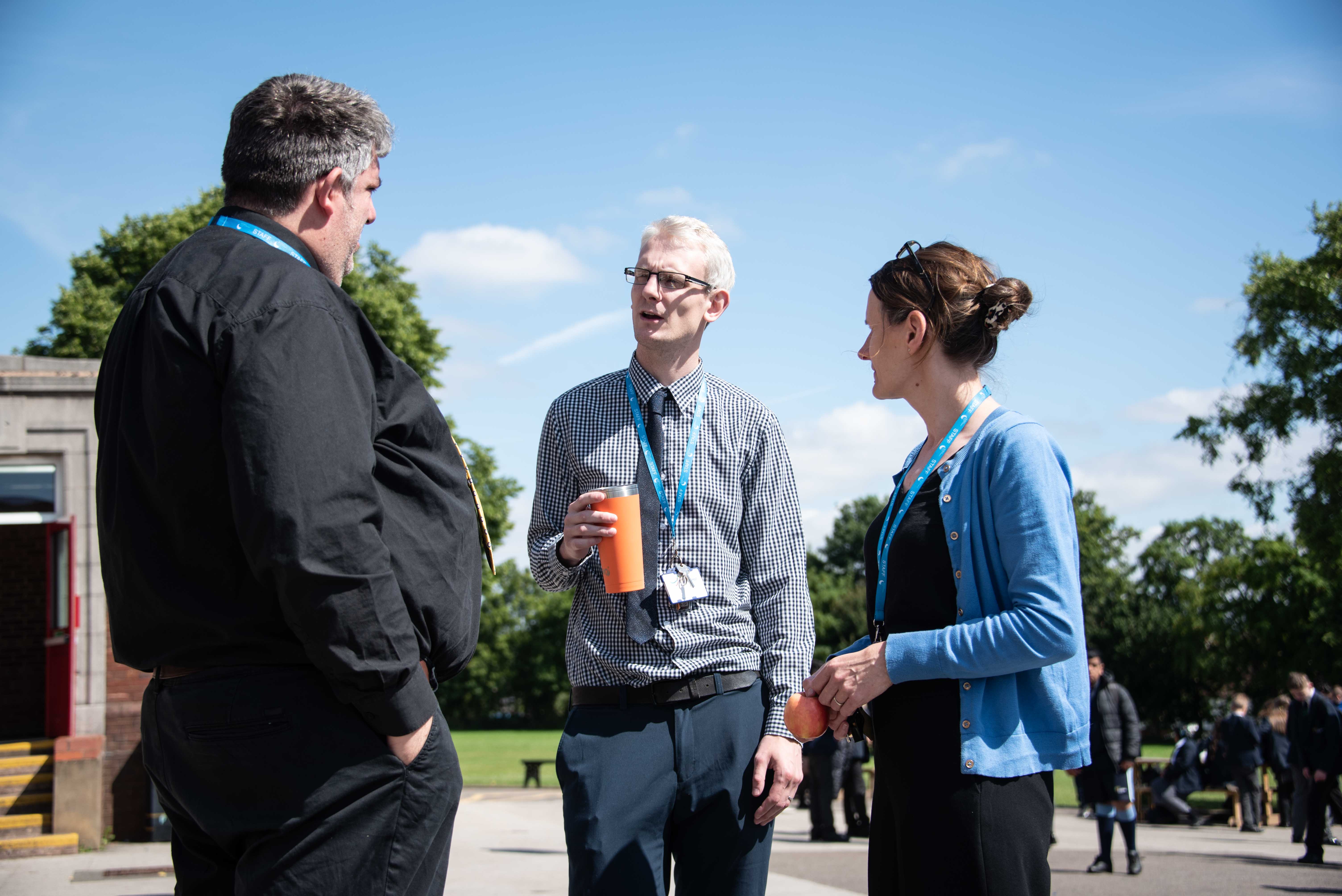 Three teachers talking in the playground