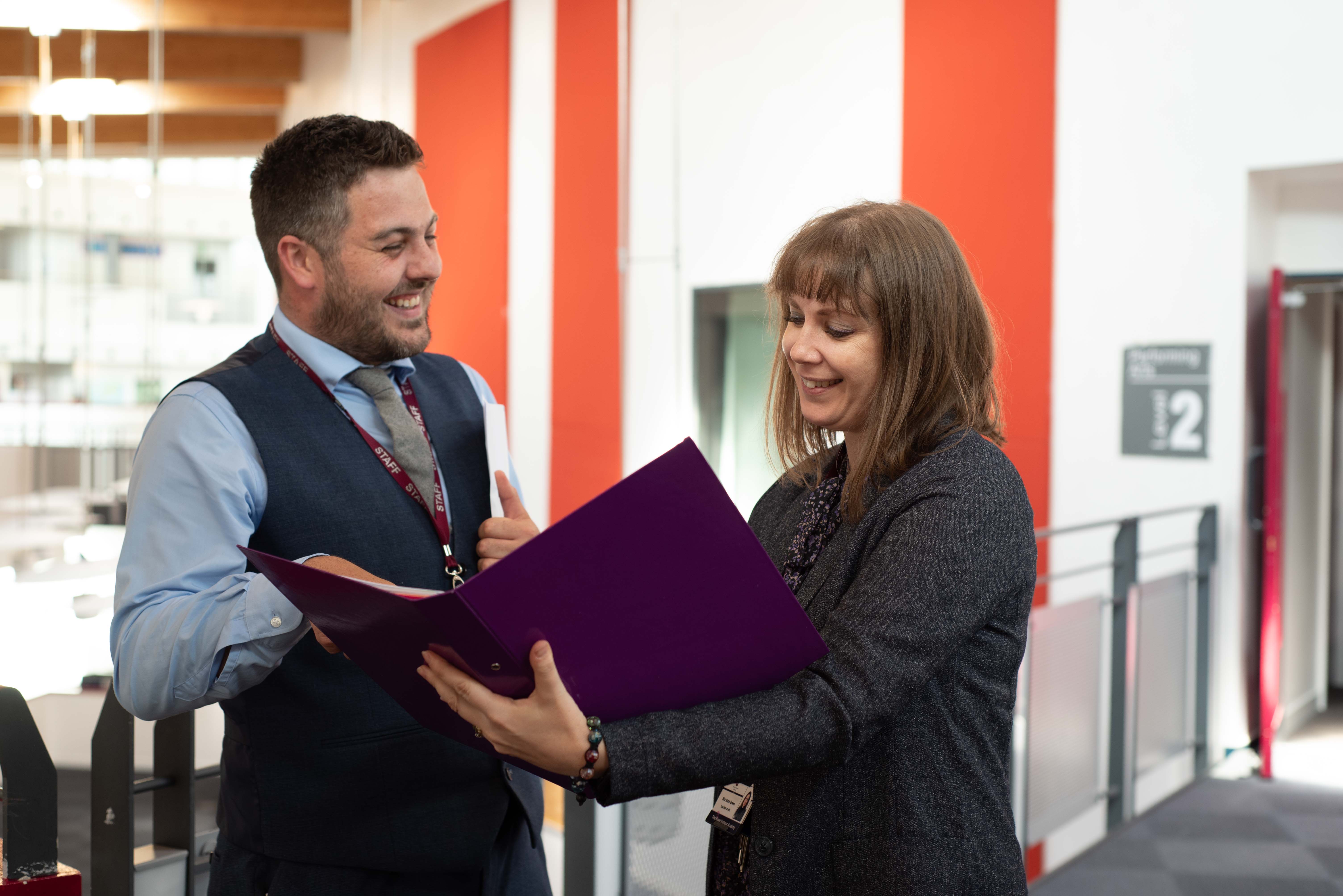 Two teachers looking at a folder