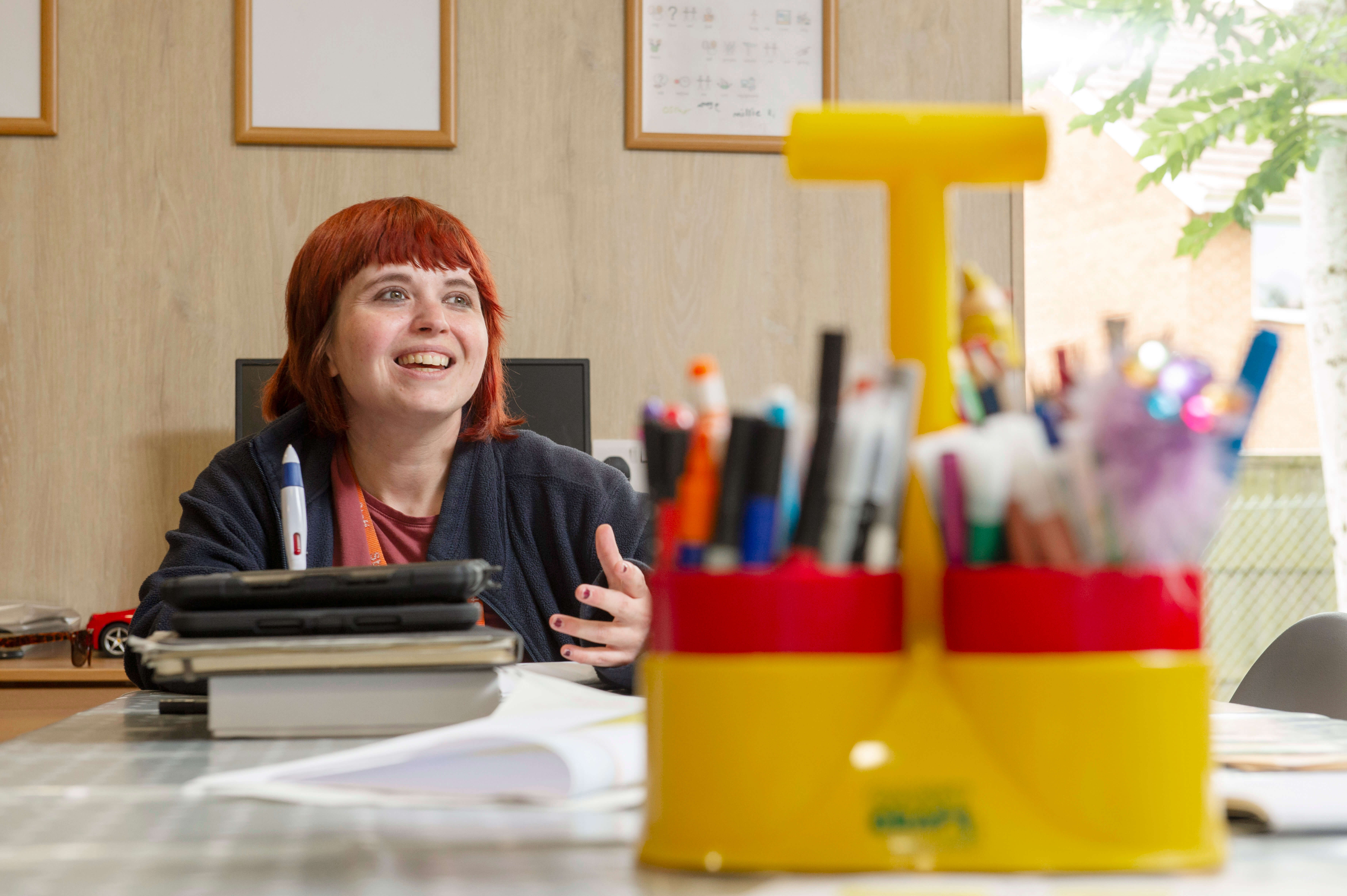 Teacher sitting down and smiling 