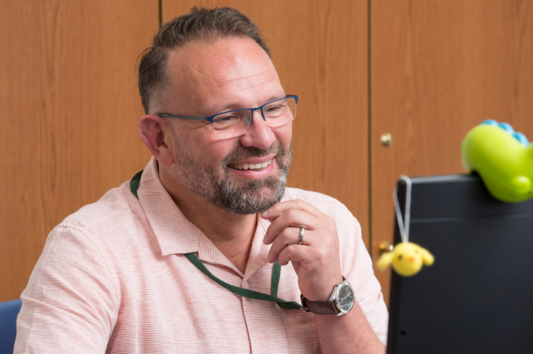 Teacher smiling in his desk in staffroom 