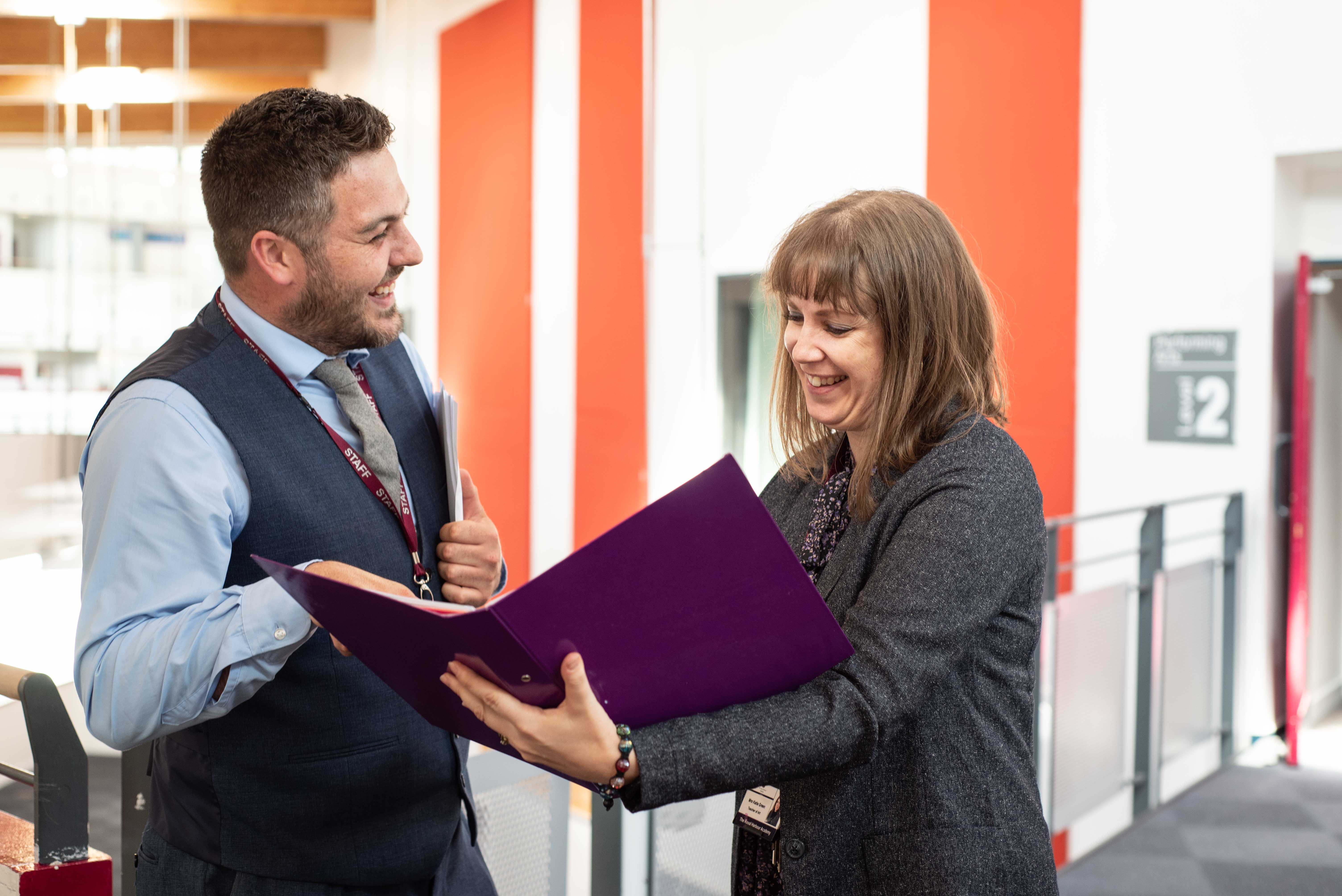Two teachers looking at a folder