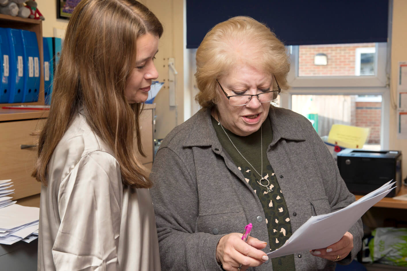 Two women talking in school office 