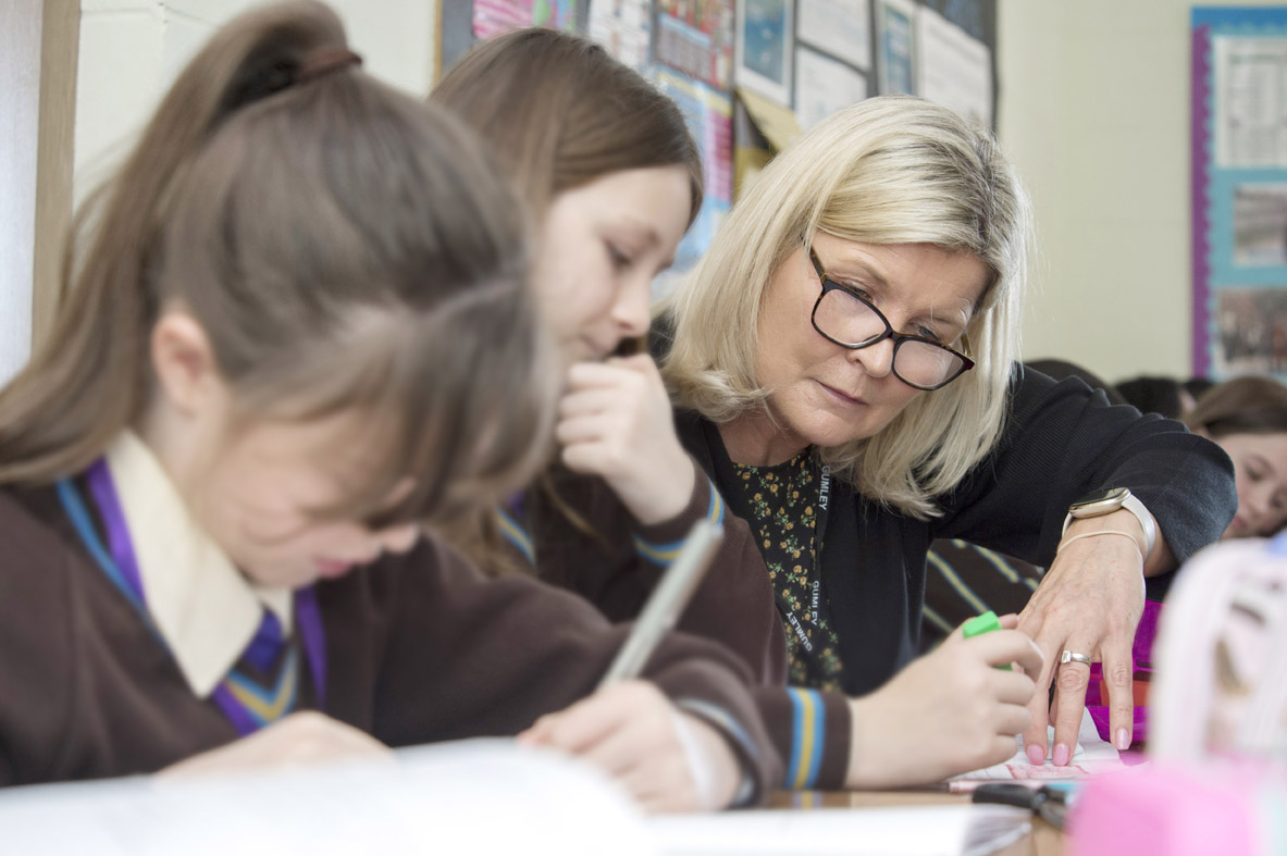 Teaching assistant helping pupil 