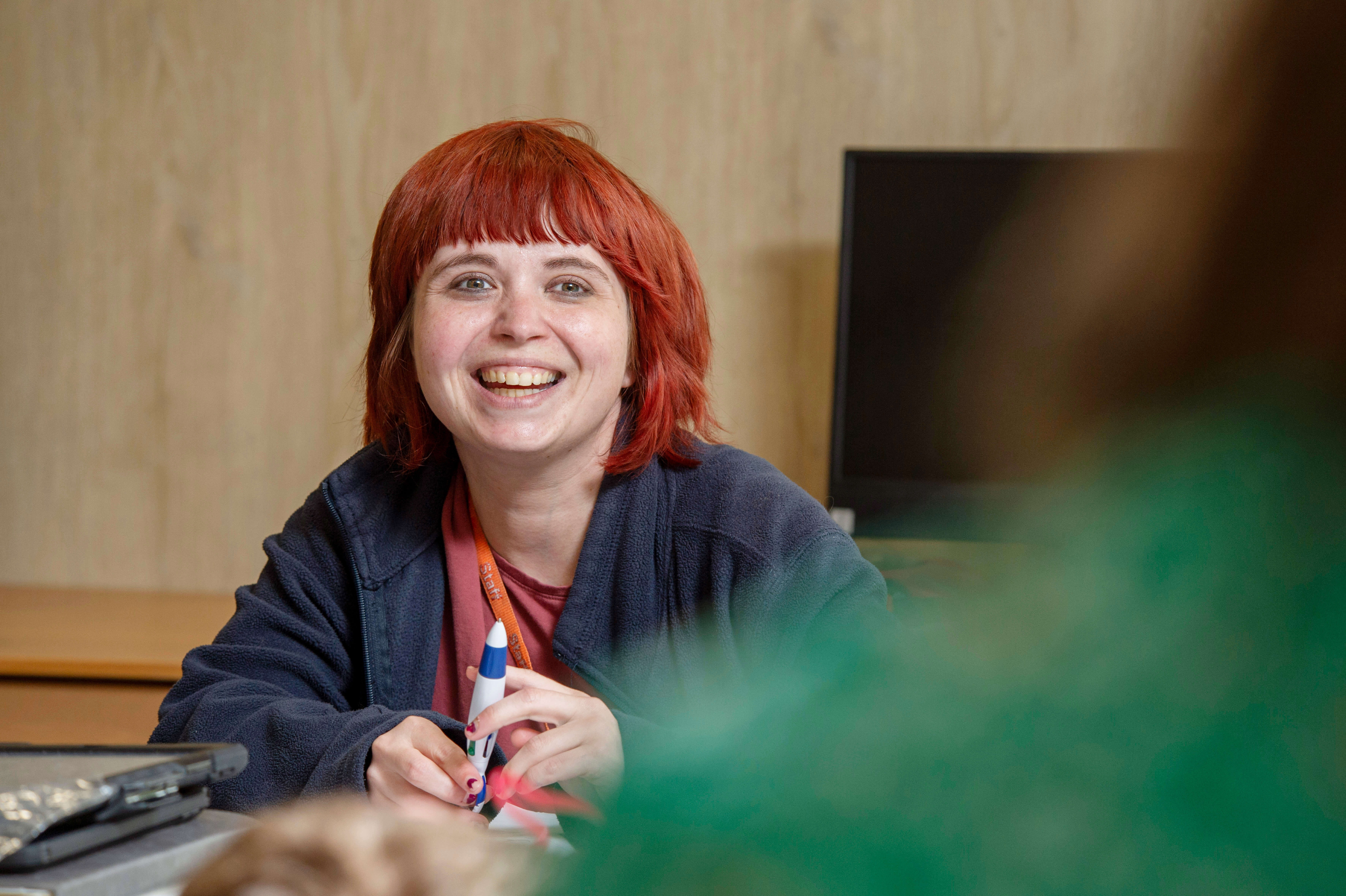 Teacher sitting down and smiling at another member of staff