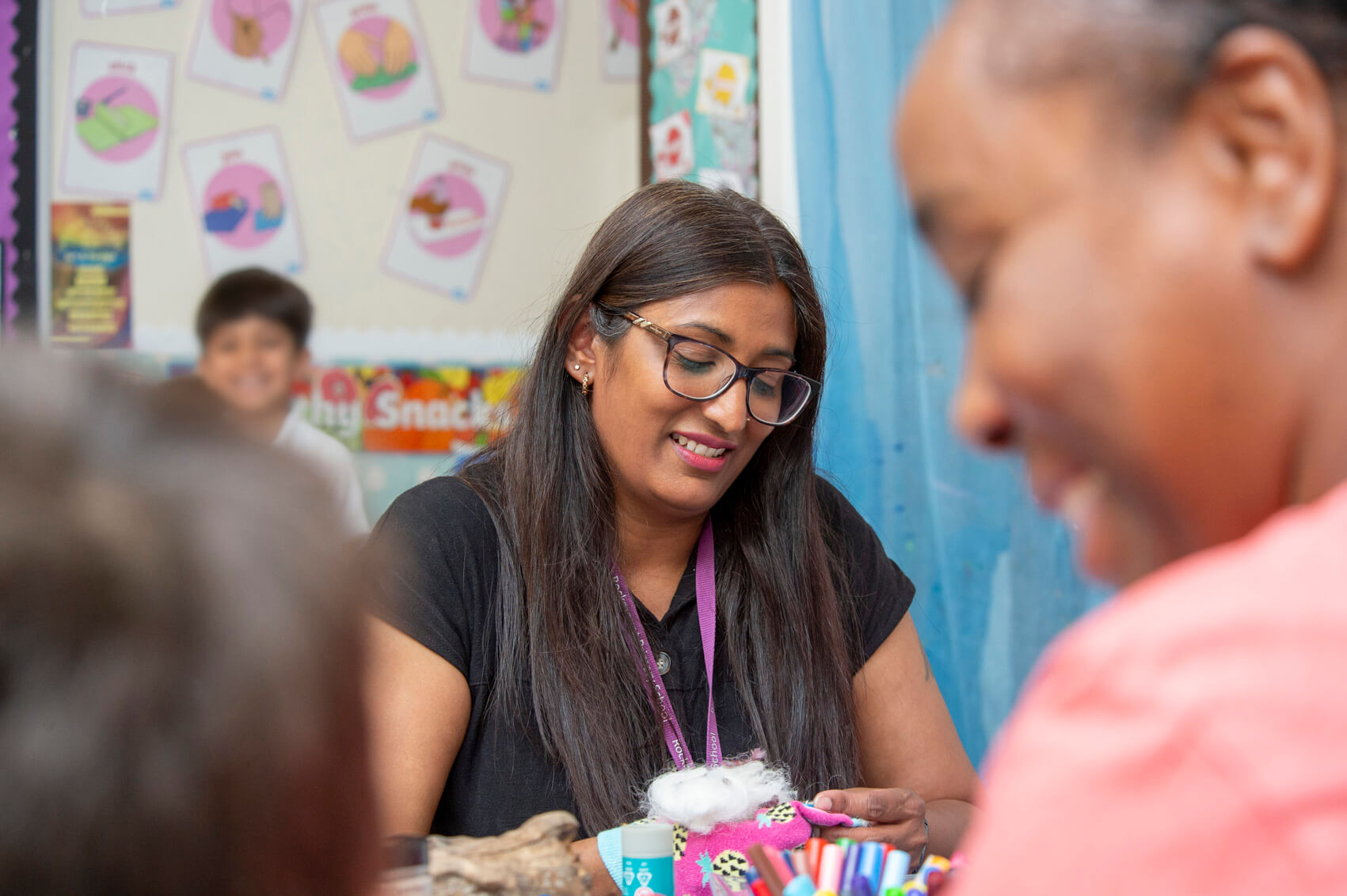 A teaching assistant smiling in a classroom 