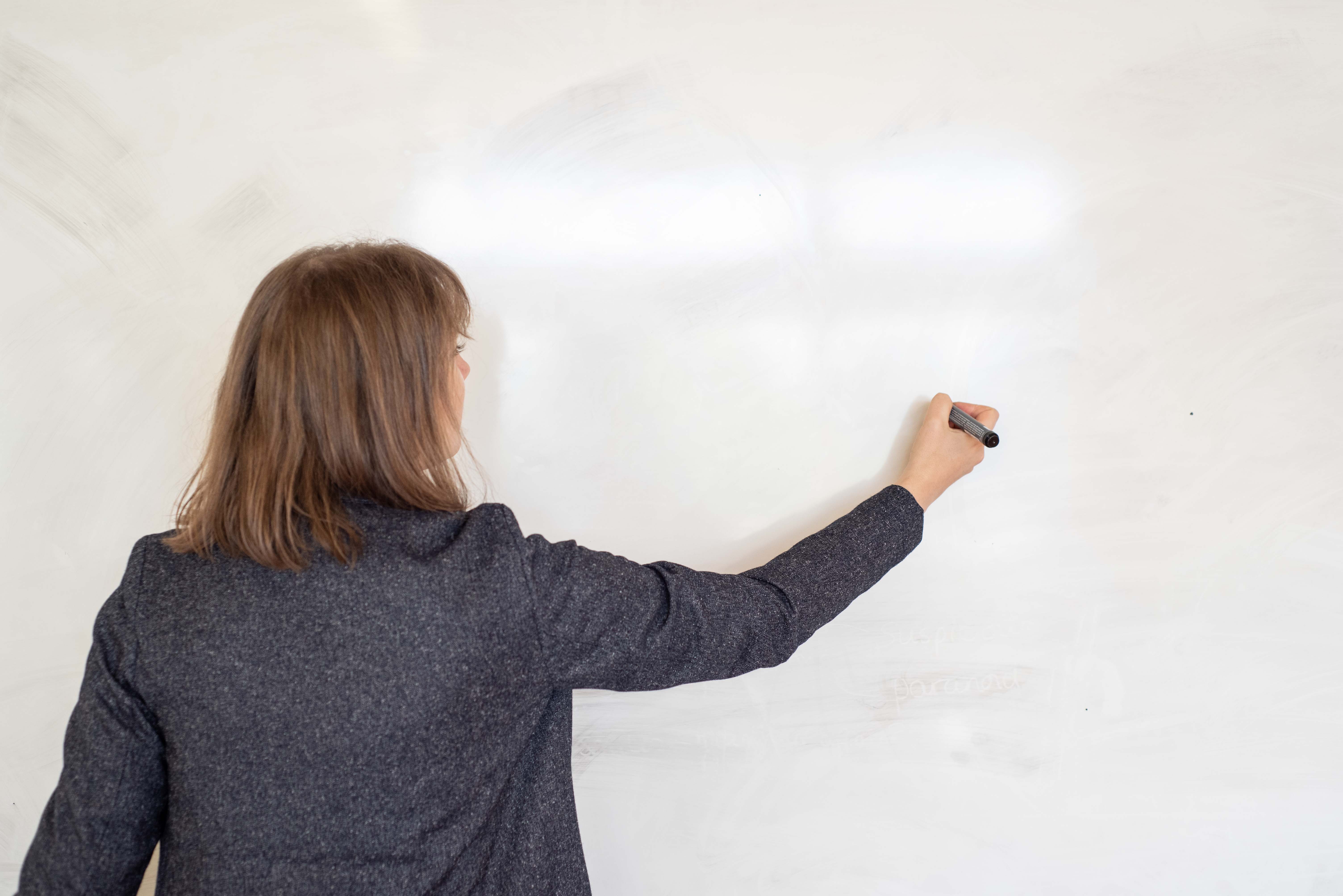 Teacher writing on a whiteboard