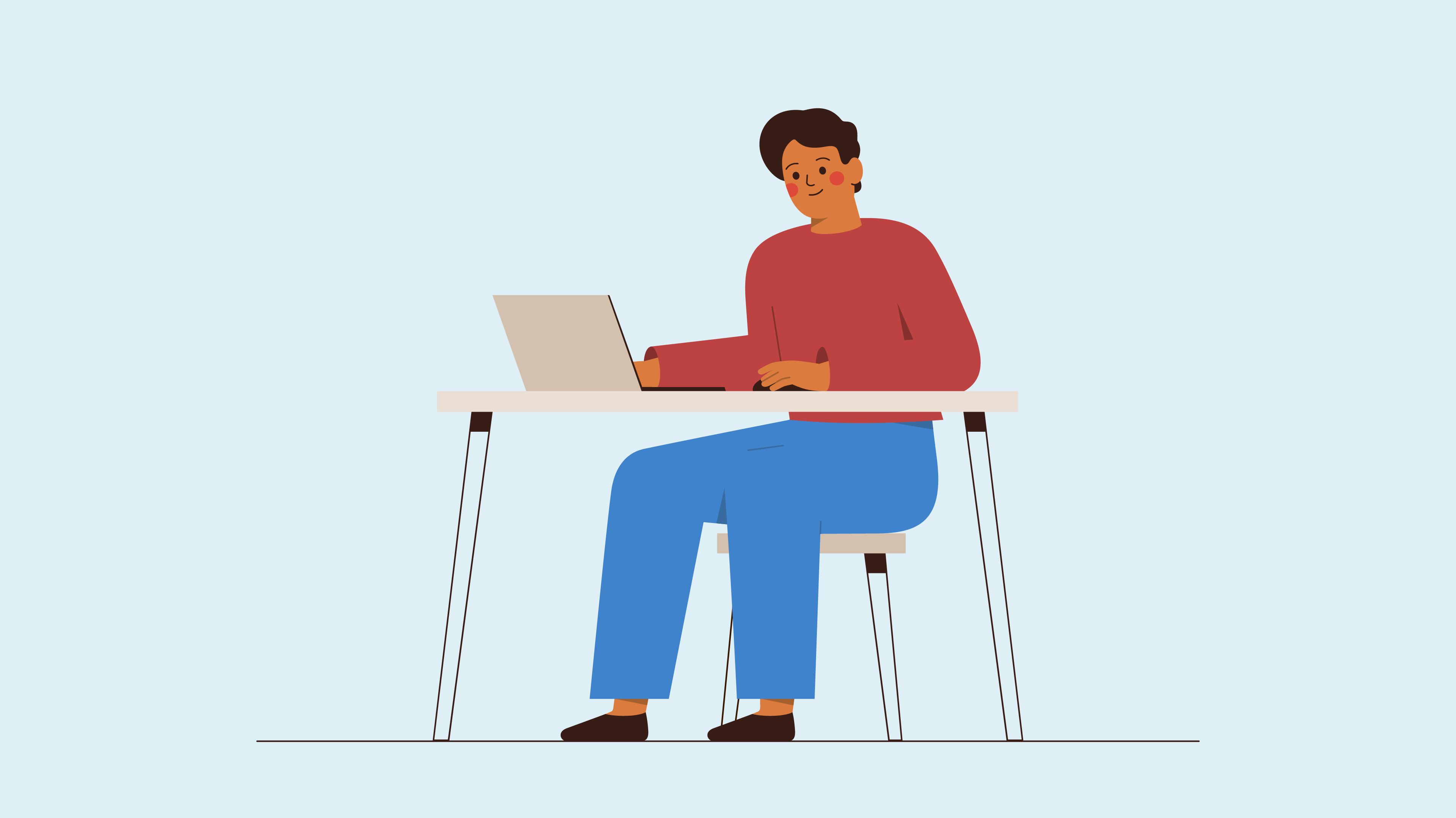 Man sitting on a desk working on his laptop 
