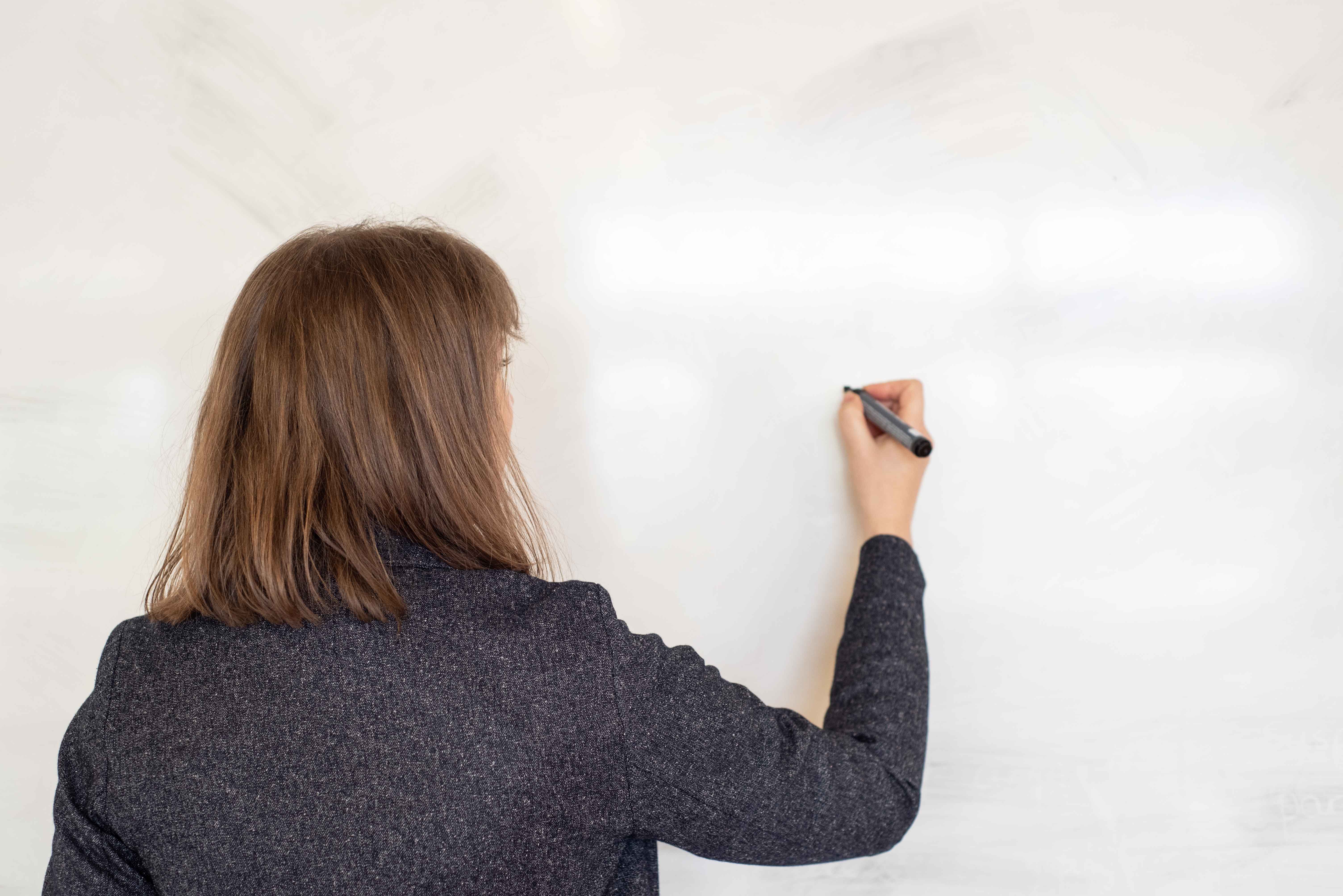 Teacher writing on a whiteboard